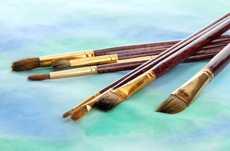 brushes on bright abstract gouache painted background