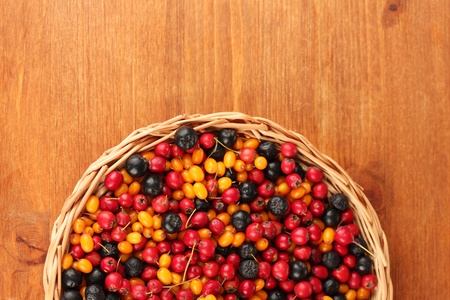 colorful autumn berries on wicker mat on wooden background close-upの写真素材