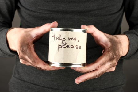 homeless man asks for help, on black background close-upの写真素材
