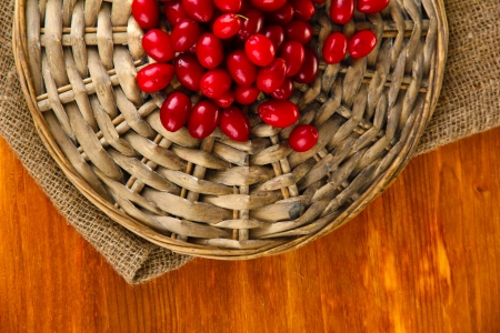 fresh cornel berries on wicker mat on wooden background close-upの写真素材