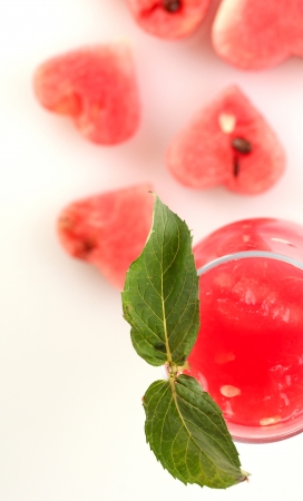 A glass of fresh watermelon juice and hearts of watermelon on white background close-upの写真素材