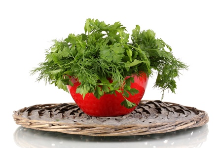 Red pot with parsley and dill on wicker cradle isolated on whiteの写真素材