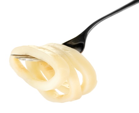 boiled squid rings on the fork on white background close-up