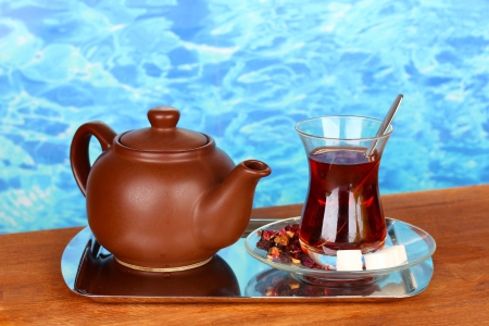 glass of Turkish tea and kettle on color backgroundの写真素材