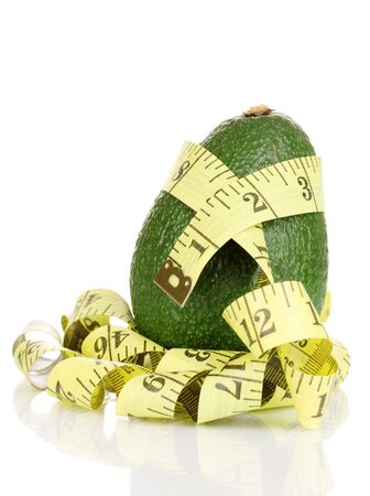 avocado with measuring tape isolated on whiteの写真素材