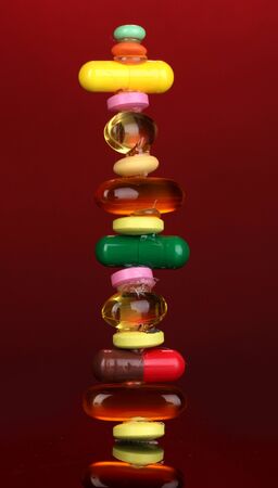Capsules and pills on red backgroundの写真素材