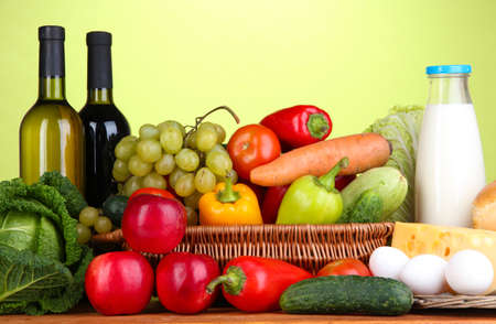 Composition with vegetables  in wicker basket on green backgroundの写真素材