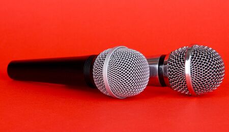 Silver and black microphones on red backgroundの写真素材