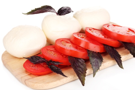 tasty mozzarella with tomatoes on chopping board isolated on whiteの写真素材