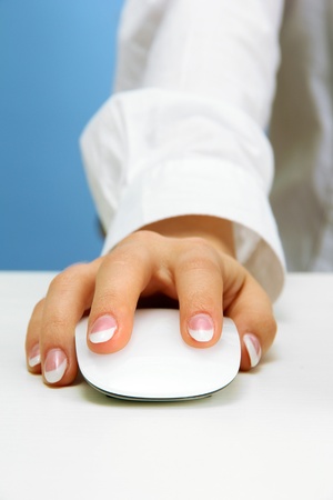 female hand pushing keys of pc mouse, on blue backgroundの写真素材