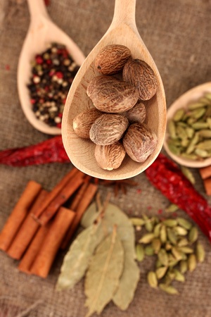 Nutmeg and other spices on sackcloth backgroundの写真素材