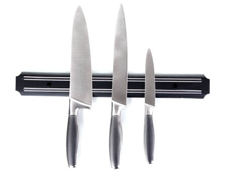 Set of knives on magnetic holder isolated on white