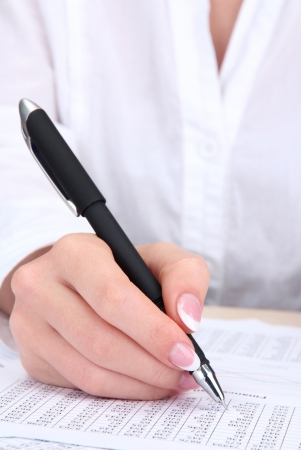 Closeup of businesswoman hand, writing on paperの写真素材