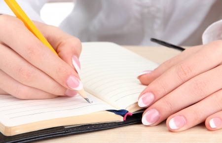 Closeup of businesswoman hands, writing on paperの写真素材