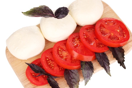 tasty mozzarella with tomatoes on chopping board isolated on whiteの写真素材