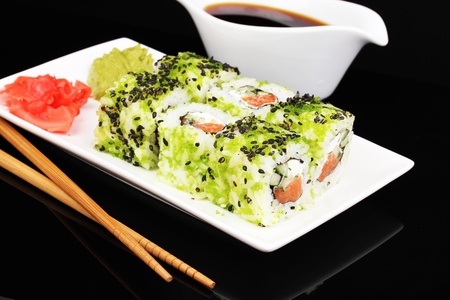 Tasty rolls served on white plate with chopsticks isolated on blackの写真素材
