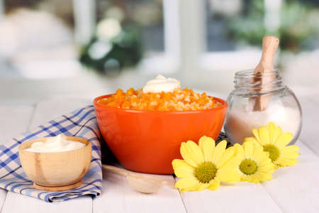Useful pumpkin porridge in color plate on wooden table on window backgroundの写真素材