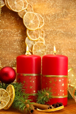 Two candles and christmas decorations, on golden backgroundの写真素材