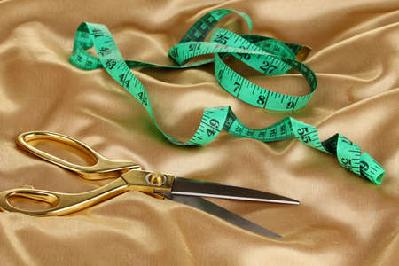 Metal scissors on gold fabricの写真素材