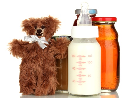 Baby food, bottle of milk and juice with teddy bear isolated on whiteの写真素材