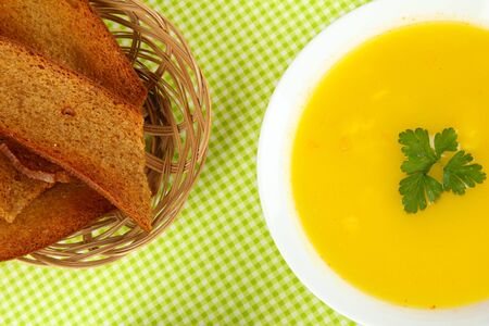 Fragrant soup in white plate on green tableclothの写真素材