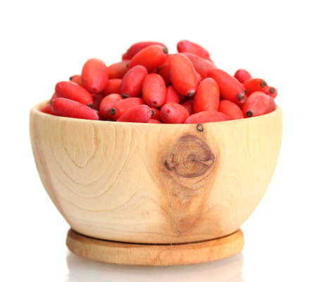 ripe barberries in wooden bowl isolated whiteの写真素材
