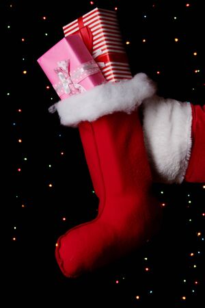 Santa Claus hand holding gifts on bright backgroundの写真素材