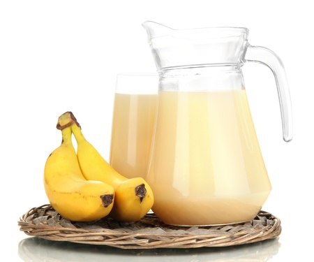 Full glass and jug of banana juice and bananas isolated on whiteの写真素材
