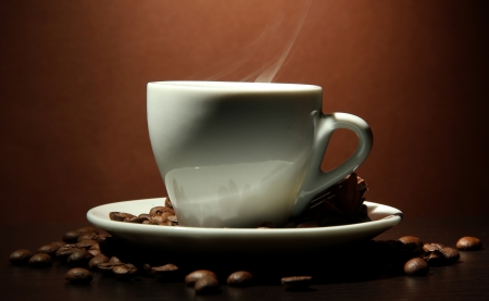 cup of coffee with beans on table, on brown backgroundの写真素材