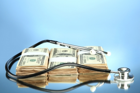 Healthcare cost concept: stethoscope and dollars on color backgroundの写真素材
