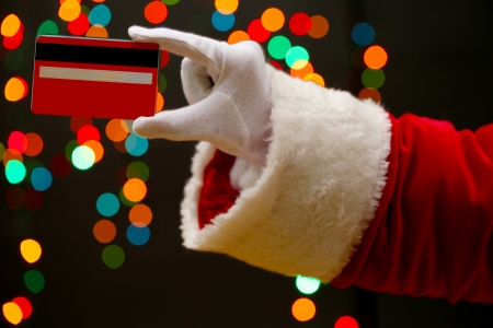 Santa Claus hand holding credit card, on garland background
の写真素材