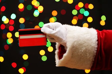 Santa Claus hand holding credit card, on garland background
の写真素材