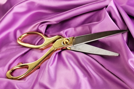 Metal scissors on purple fabricの写真素材