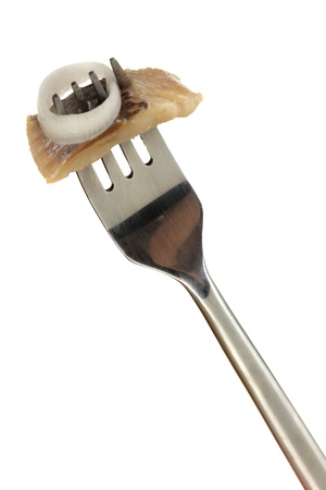 Piece of herring on fork isolated on whiteの写真素材