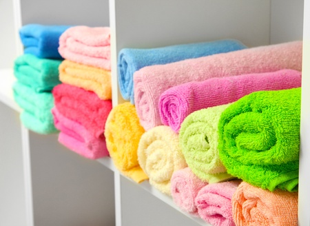 colorful towels on shelves in bathroomの写真素材