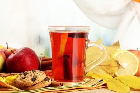 cup of hot tea and autumn leaves, on wooden tableの写真素材