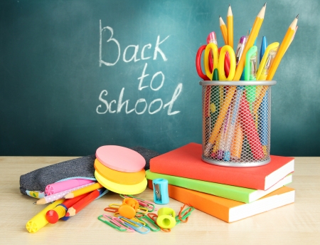 Back to school - blackboard with pencil-box and school equipment on tableの写真素材