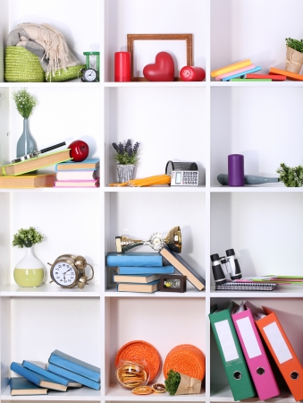 Beautiful white shelves with scattered different home related objectsの写真素材