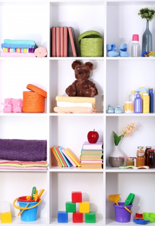 Beautiful white shelves with different baby related objectsの写真素材