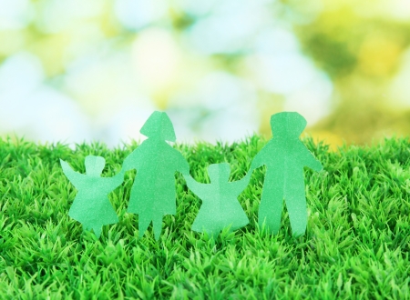 Paper people on green grass on bright backgroundの写真素材