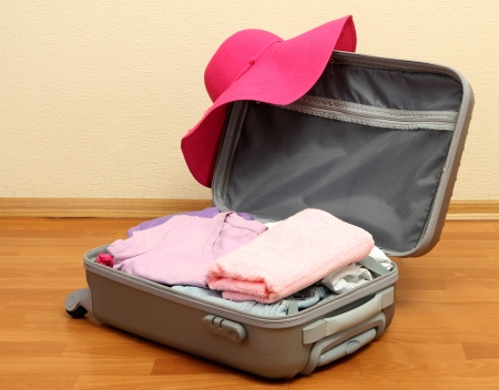 Open silver suitcase with clothing in roomの写真素材