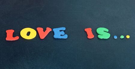 Phrase LOVE IS in colorful letters on school board close-upの写真素材