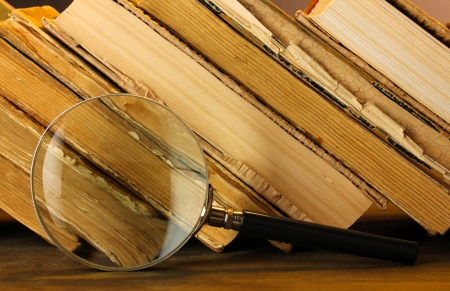 Magnifying glass and books on tableの写真素材
