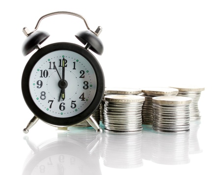 Alarm clock with coins isolated on white