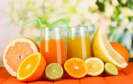 Lots ripe citrus with juices on wooden table on natural backgroundの写真素材