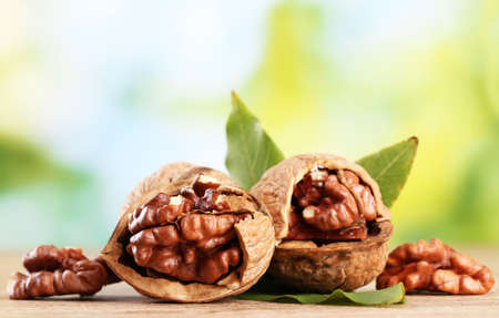 walnuts with green leaves, on green backgroundの写真素材