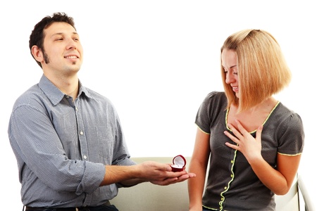 Young man making offer of marriage and giving ring to woman isolated on white