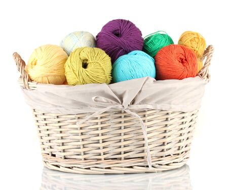 Colorful yarn balls in wicker basket isolated on whiteの写真素材