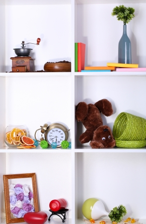 Beautiful white shelves with scattered different home related objectsの写真素材