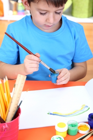 Cute little boy painting in his albumの写真素材